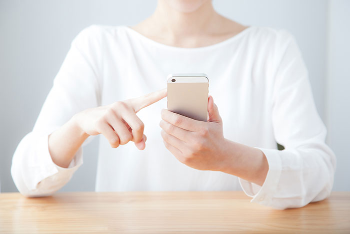 携帯で予約する女性